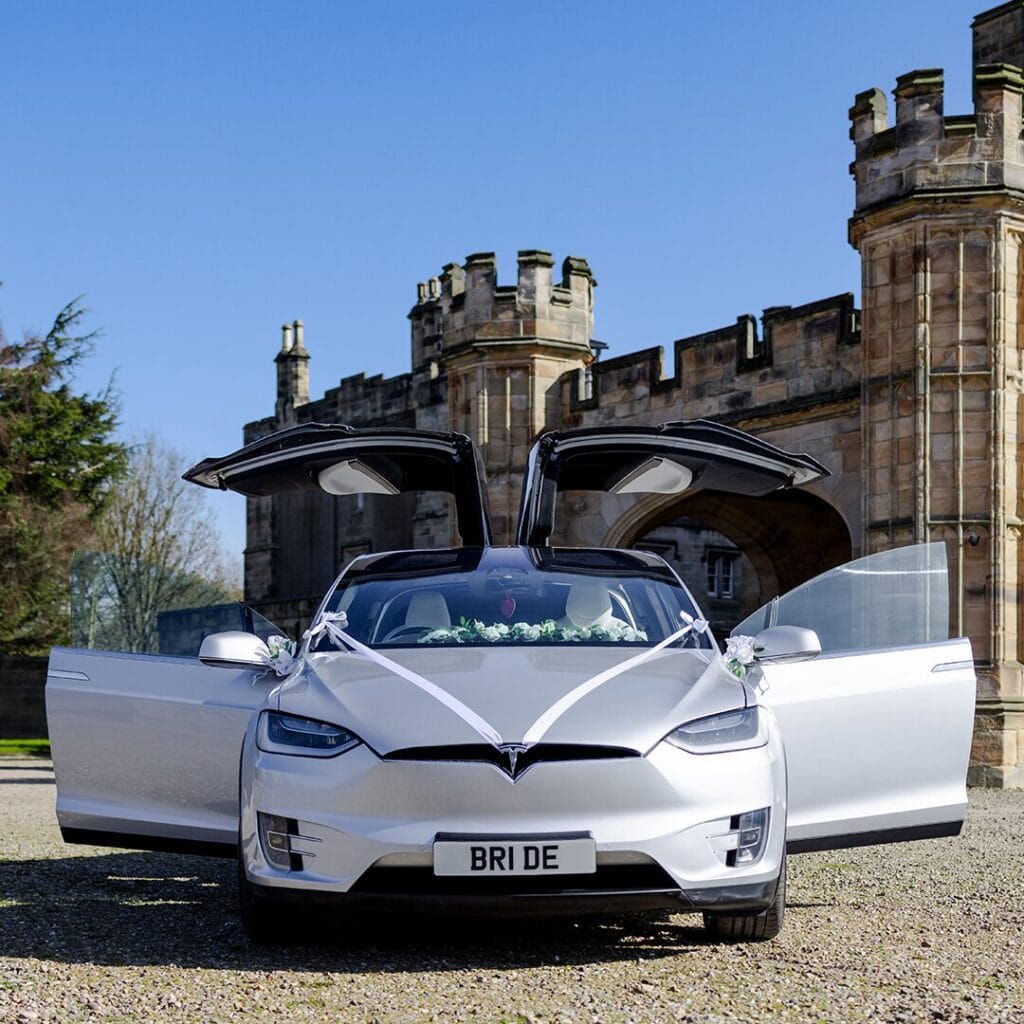 Bride exits electric wedding car with falcon wing doors open